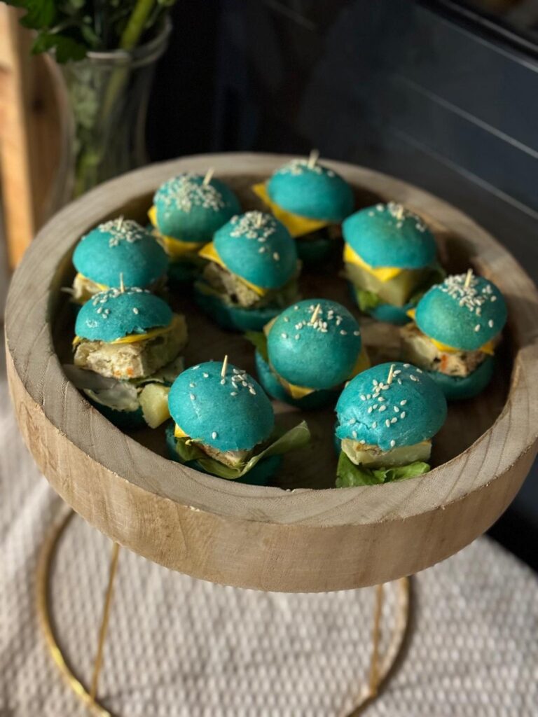 Mini burgers colorés sur présentoir en bois